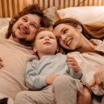 A joyful family bonding together while lying in bed, creating precious moments.